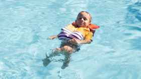 Un niño con la camiseta antiahogo en una piscina.