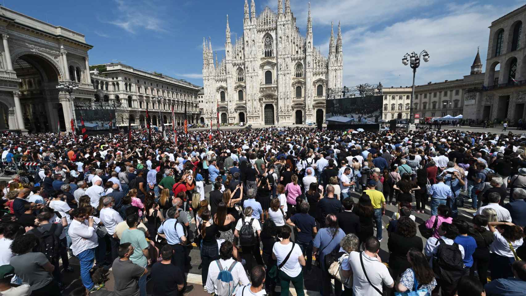 La plaza del Duomo de Milán se llena de gente esperando la llegada del coche fúnebre.