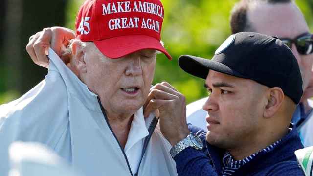 Walt Nauta, asistente personal de Trump, camina con el expresidente en su club de golf en Virginia.
