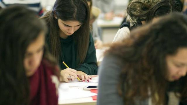 Varios estudiantes realizando un examen en la universidad.