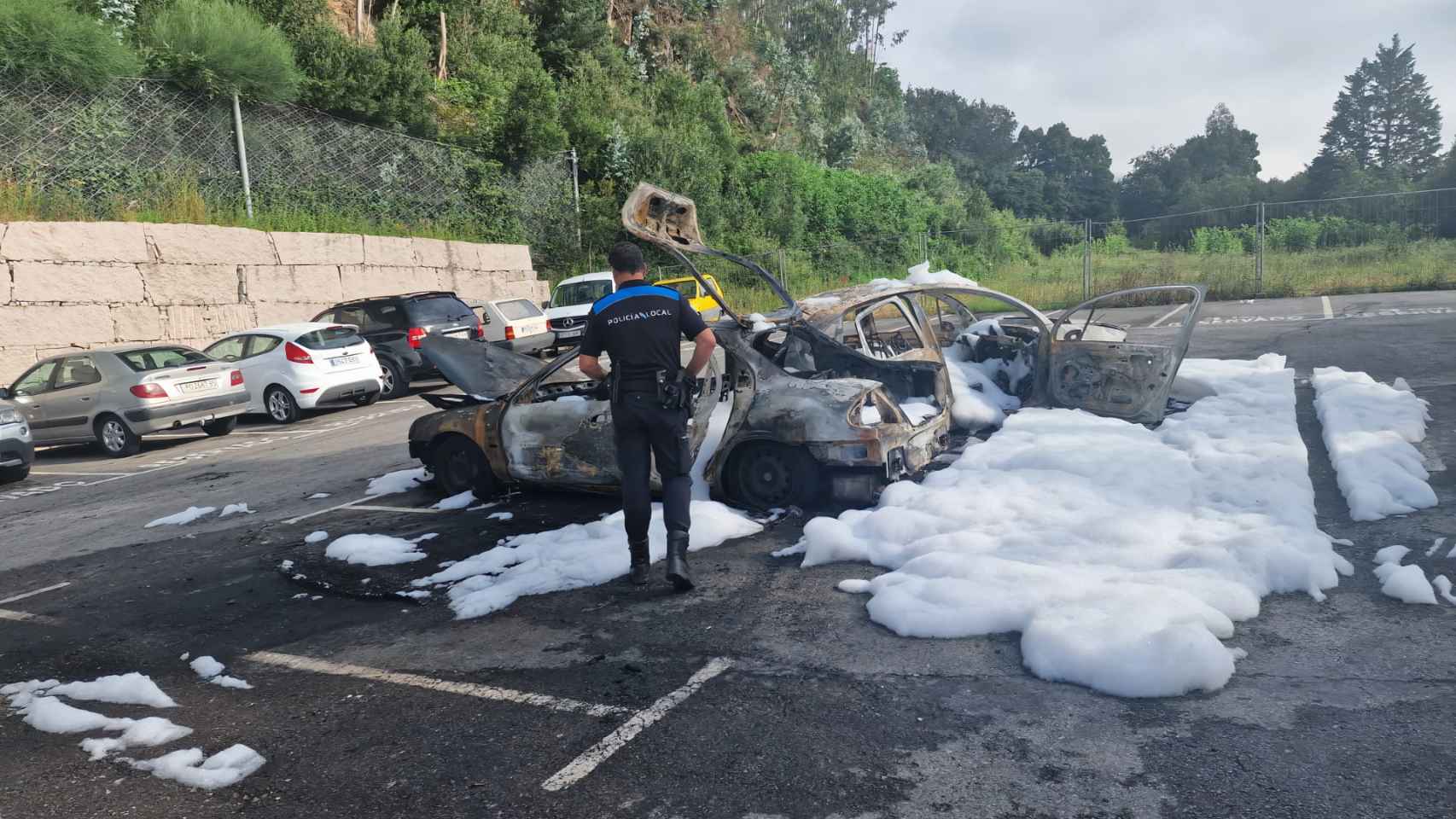 Un agente junto a los coches calcinados en la mañana de este miércoles.