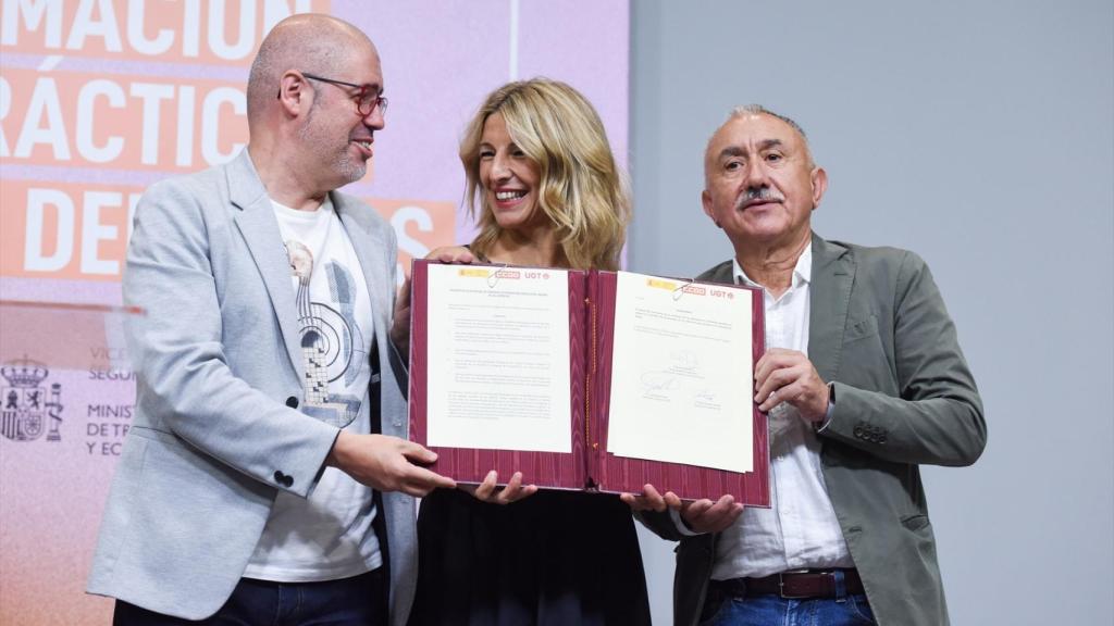 La vicepresidenta segunda y ministra de Trabajo y Economía Social, Yolanda Díaz (c), firma con los secretarios generales de CCOO, Unai Sordo (i) y de UGT, Pepe Álvarez (d).