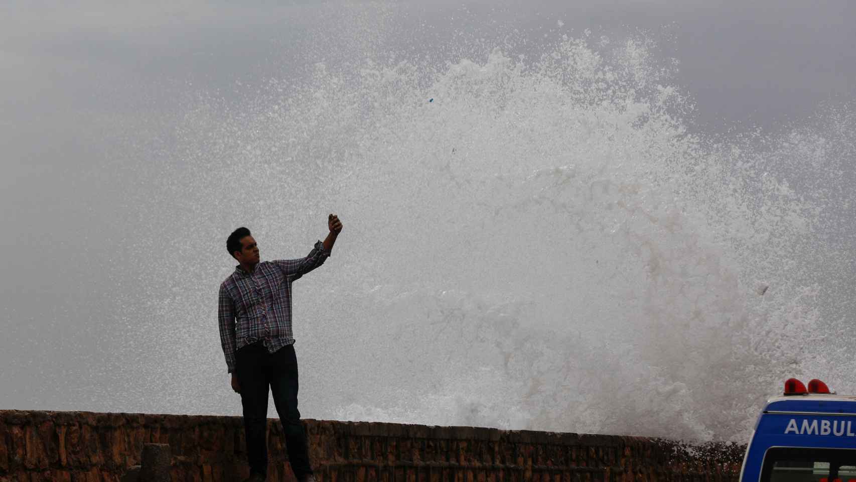 Un hombre se toma un selfie junto a una ola antes de la llegada del ciclón Biparjoy a Pakistán.