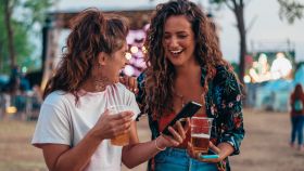 Dos mujeres en un festival de música con bebidas.