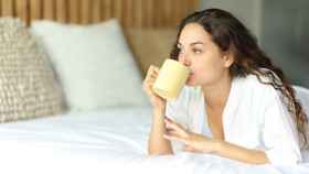 Mujer desayunando en la cama. Foto: iStock.