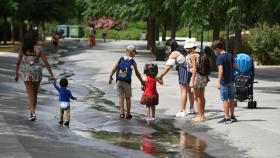Varios niños pasan por un arroyo de agua en el Parc Central, a 12 de agosto de 2021, en Valencia.