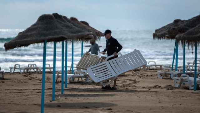 Un hombre coloca unas hamacas en una playa valenciana, hace unas semanas.