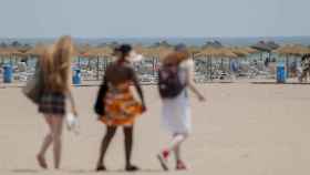 Varias personas entran en una playa valenciana, este miércoles.