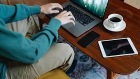 Un hombre utilizando una tablet, un ordenador y un teléfono móvil.