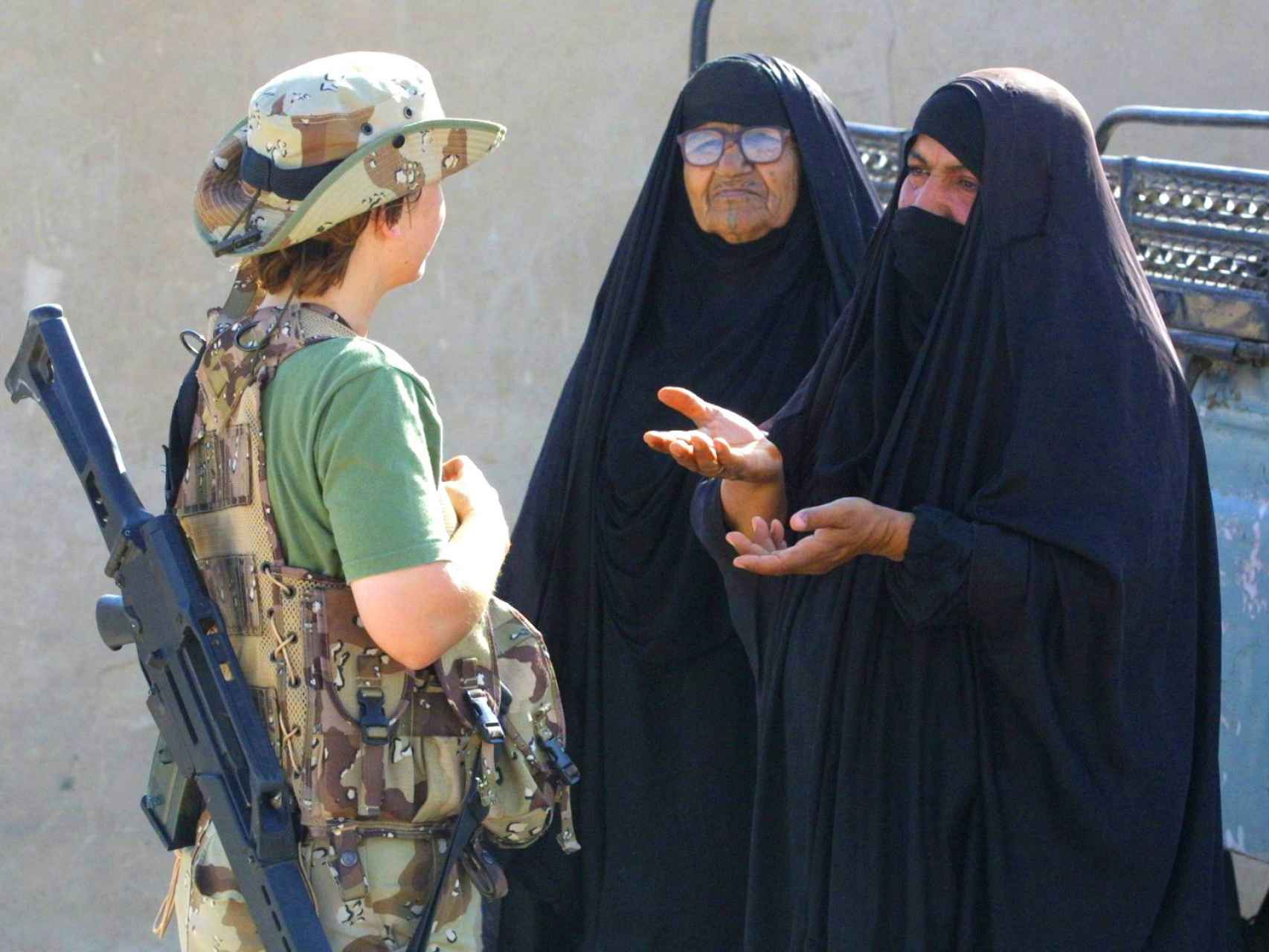 Una militar española junto a dos mujeres en una operación internacional.