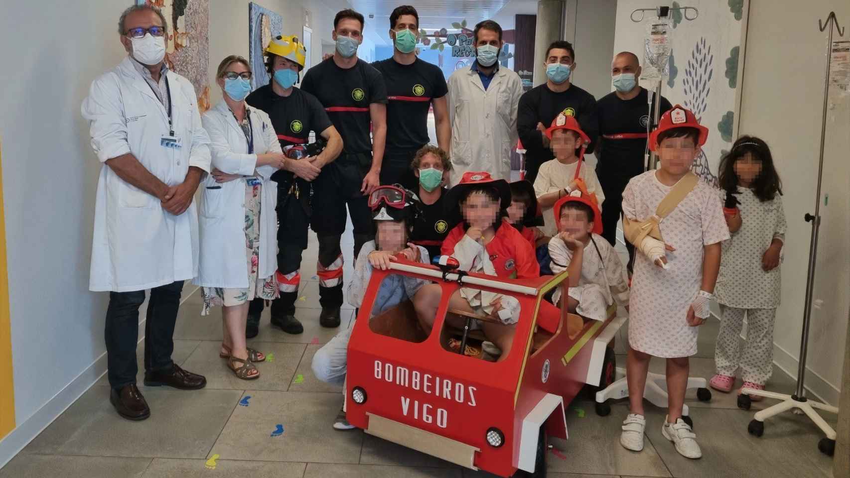 Los bomberos con personal del hospital y los niños que recibieron la sorpresa.