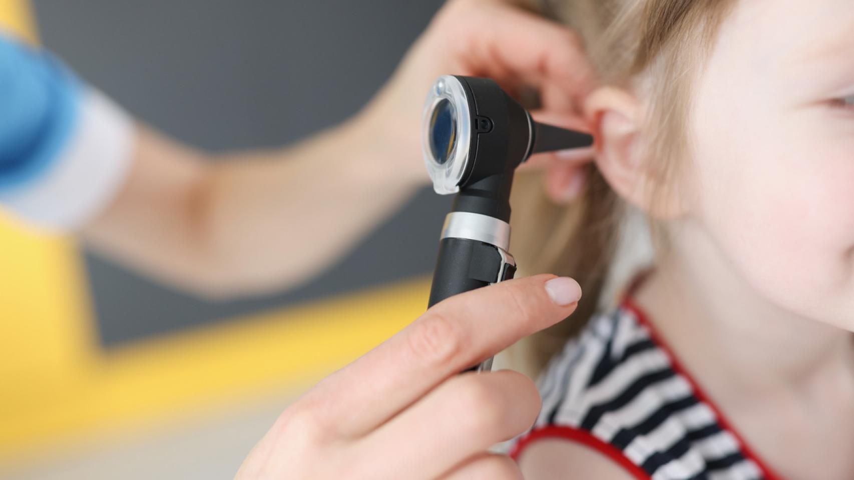 Una doctora mirando los oídos de una niña.