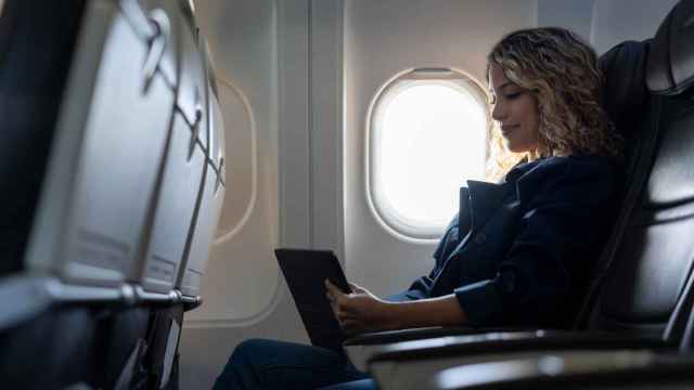 Mujer sentada en el avión (iStock)