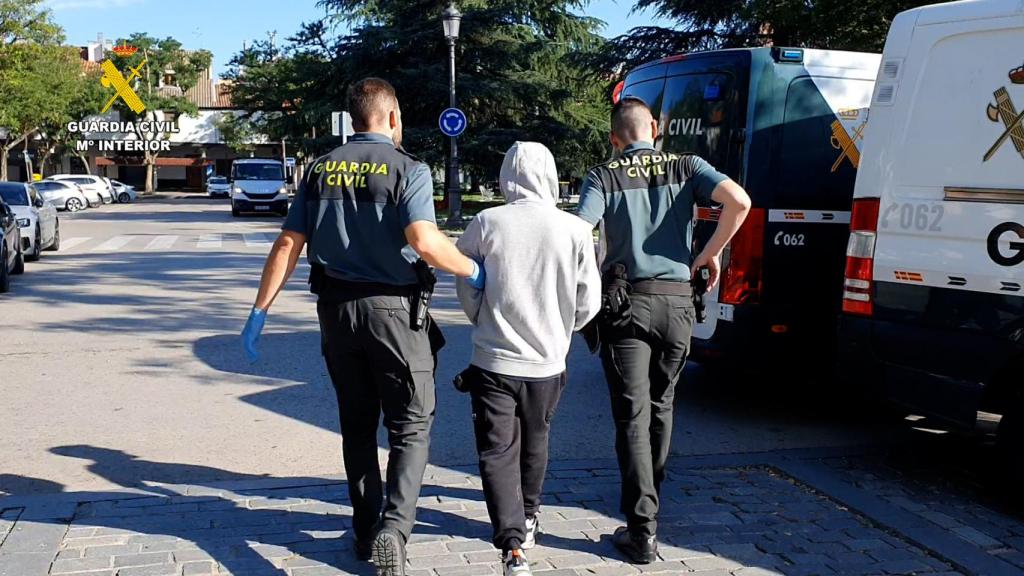 Uno de los detenidos, custodiado por dos agentes de la Guardia Civil.