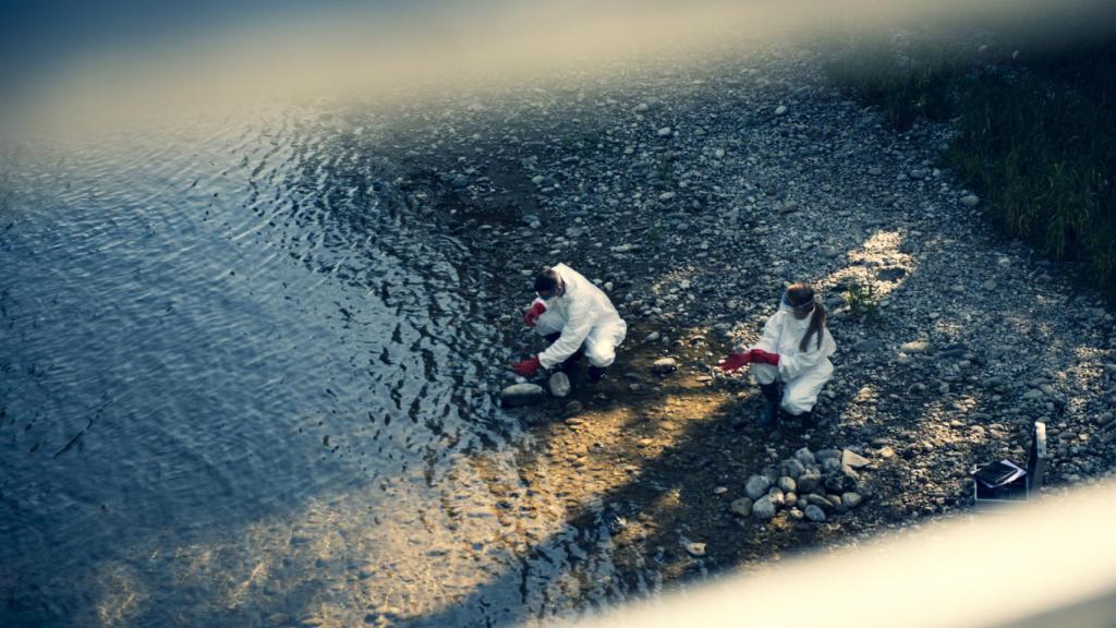 Imagen de archivo de dos investigadores recogiendo muestras de agua en la orilla de una playa.