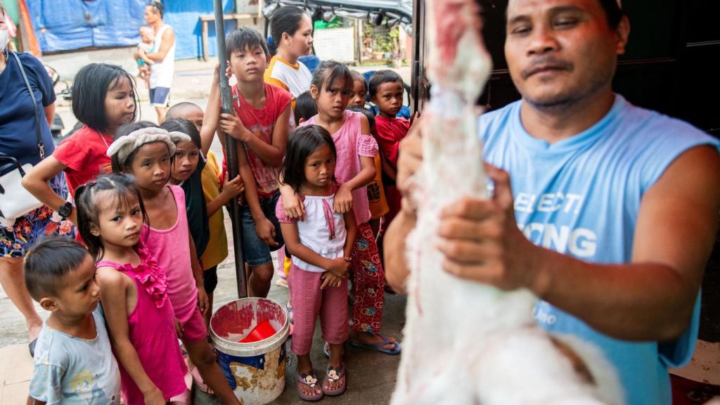 Un hombre musulmán realiza el sacrificio de un cordero durante el Eid Al Adha