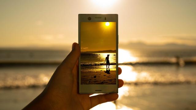 Una persona usando su teléfono móvil en la playa