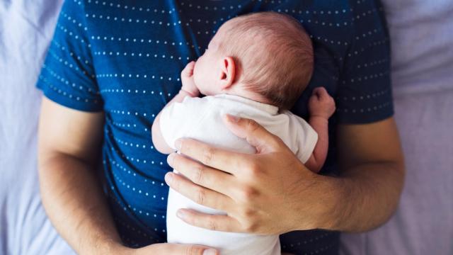 Un bebé en brazos de su padre.