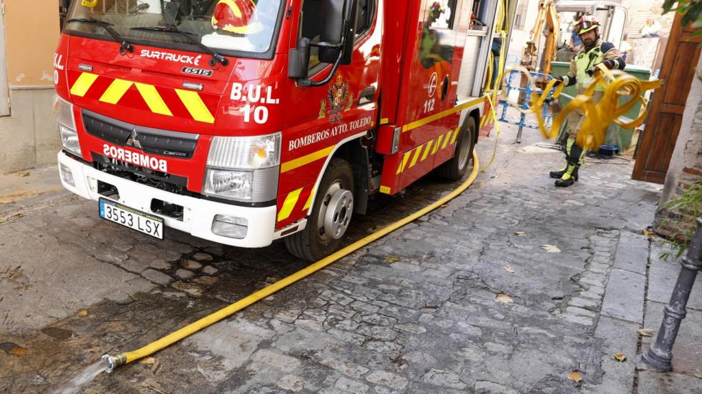 Los bomberos achicando agua en la calle Alfonso X.