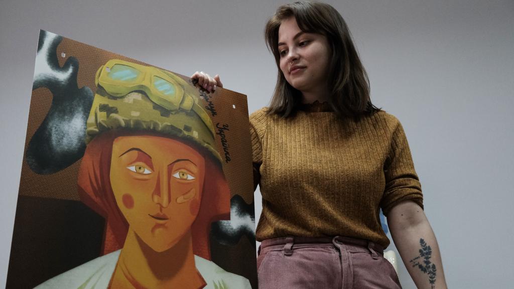 La activista ucraniana Stanislava Petlytsia posa junto a una de las obras que expusieron hace poco en Járkov, en el contexto de una de las actividades que realiza la ONG de mujeres en la que trabaja.