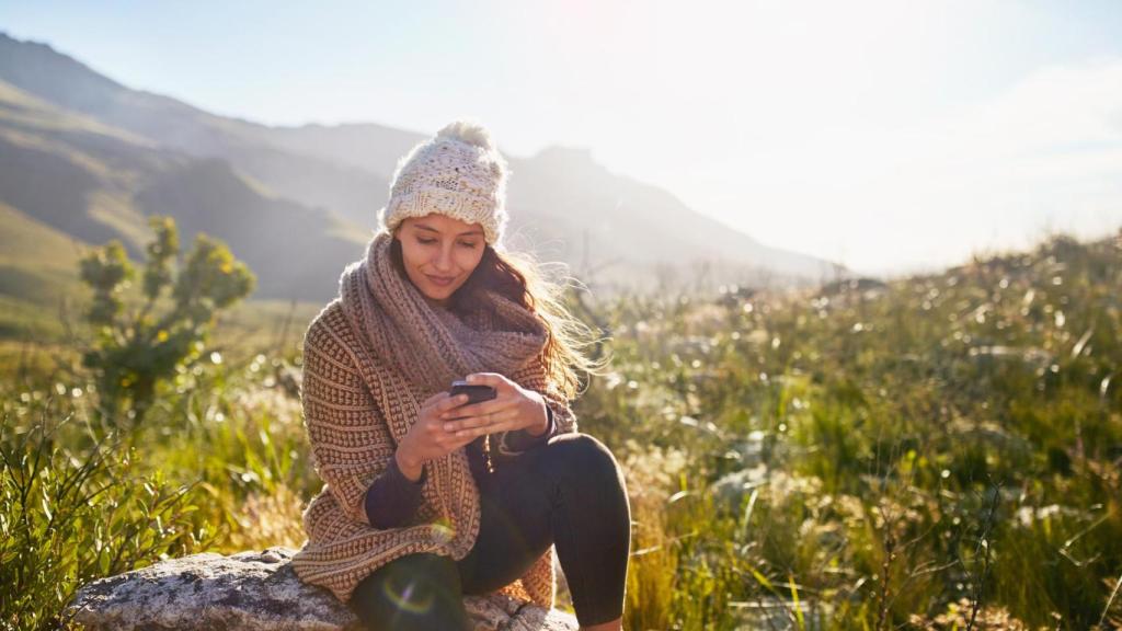 Imagen de una mujer utilizando su teléfono móvil en el campo.