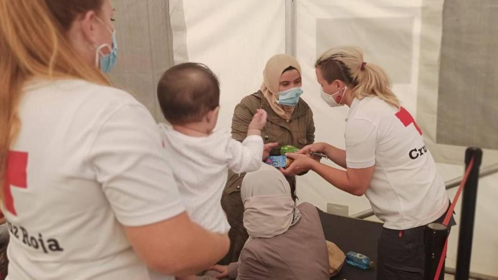 Dos voluntarias con dos mujeres y un bebé que acaban de llegar en patera a Alicante en una imagen de archivo.