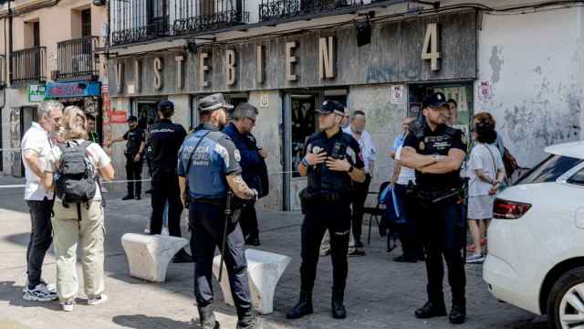 Varios agentes de Policía Nacional y Policía Local en el exterior de la tienda de ropa de trabajo ‘Vistebien’, en Tirso de Molina.