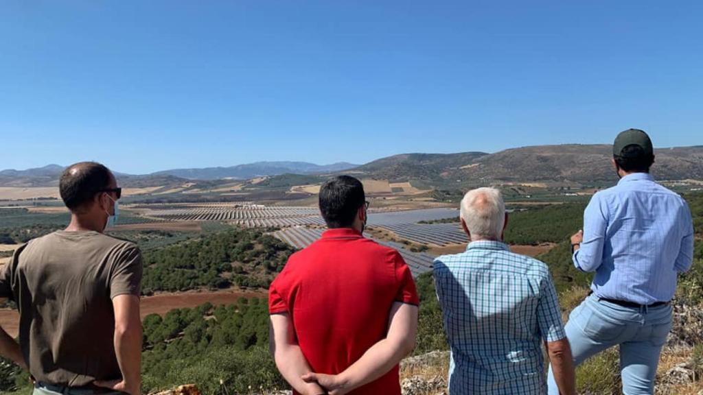 Varias personas ante una plata fotovoltaica en Almargen.