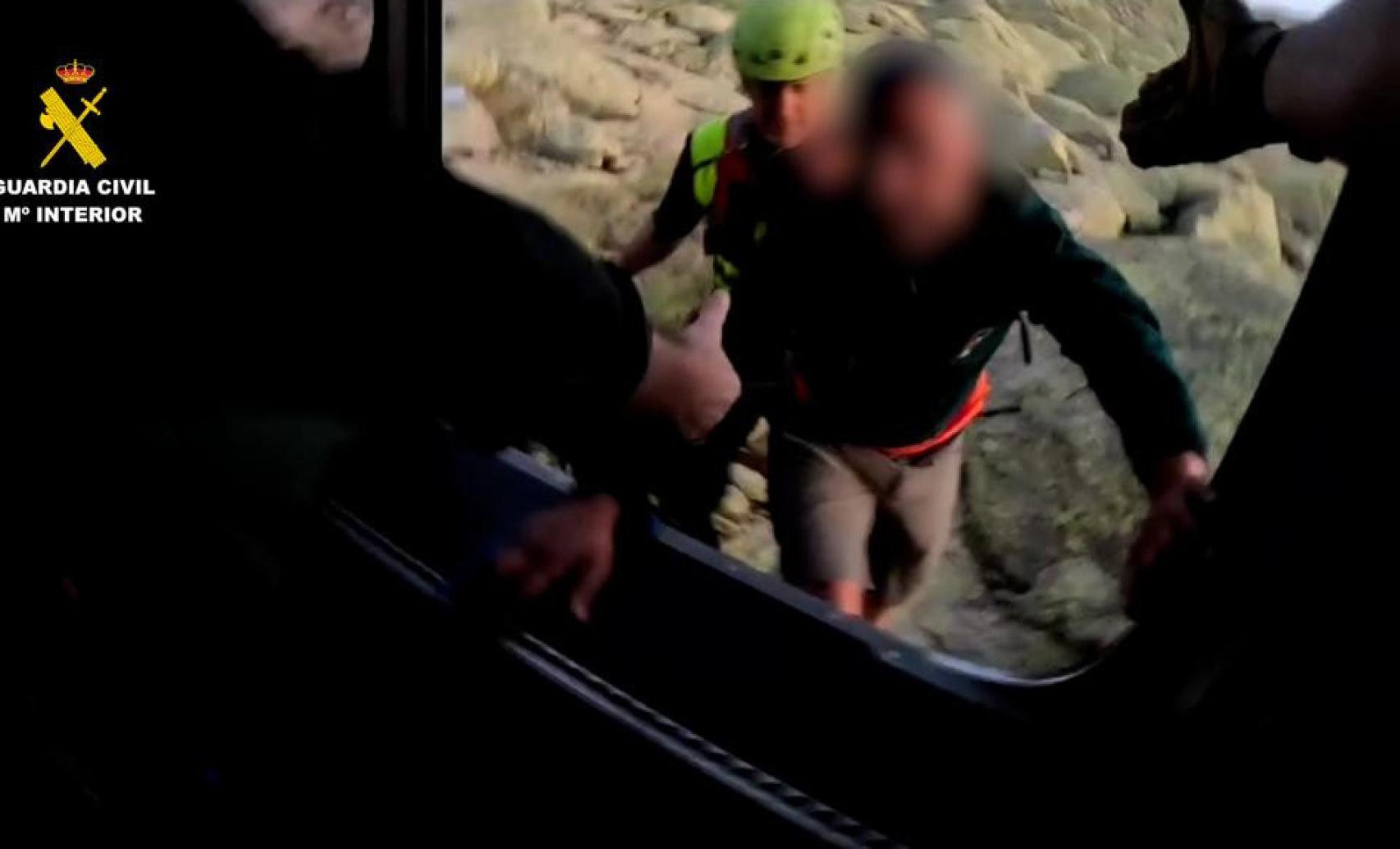 Imagen del momento en el que el montañero logra llegar al helicóptero de la Guardia Civil junto a los rescatadores