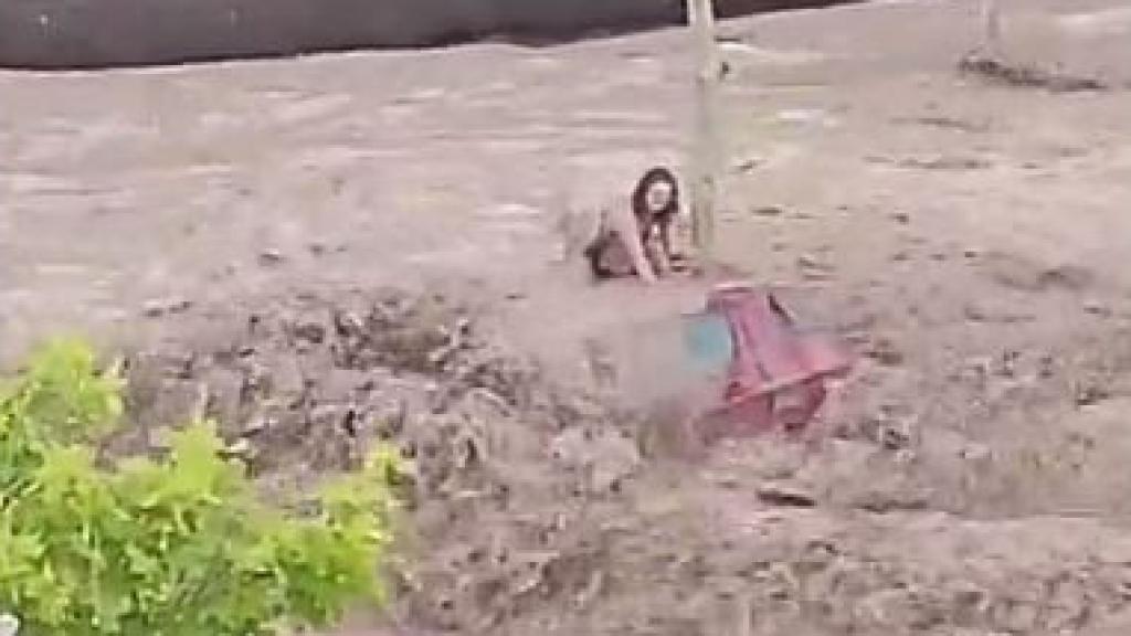 Una mujer espera subida a un coche a que lleguen los operarios de emergencias durante las inundaciones en Zaragoza.