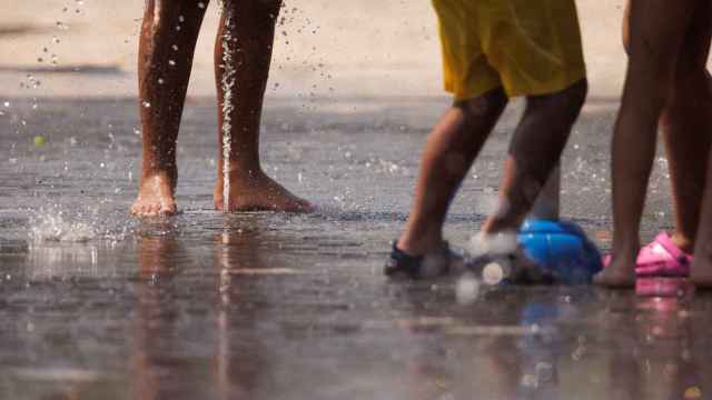 Varios niños juegan en el agua para refrescarse en Madrid Rio, a 26 de junio de 2023.