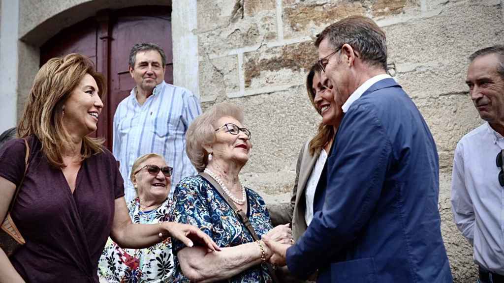 El líder del Partido Popular, Alberto Núñez Feijóo, saluda a su madre a su llegada a la plaza mayor de Os Peares.