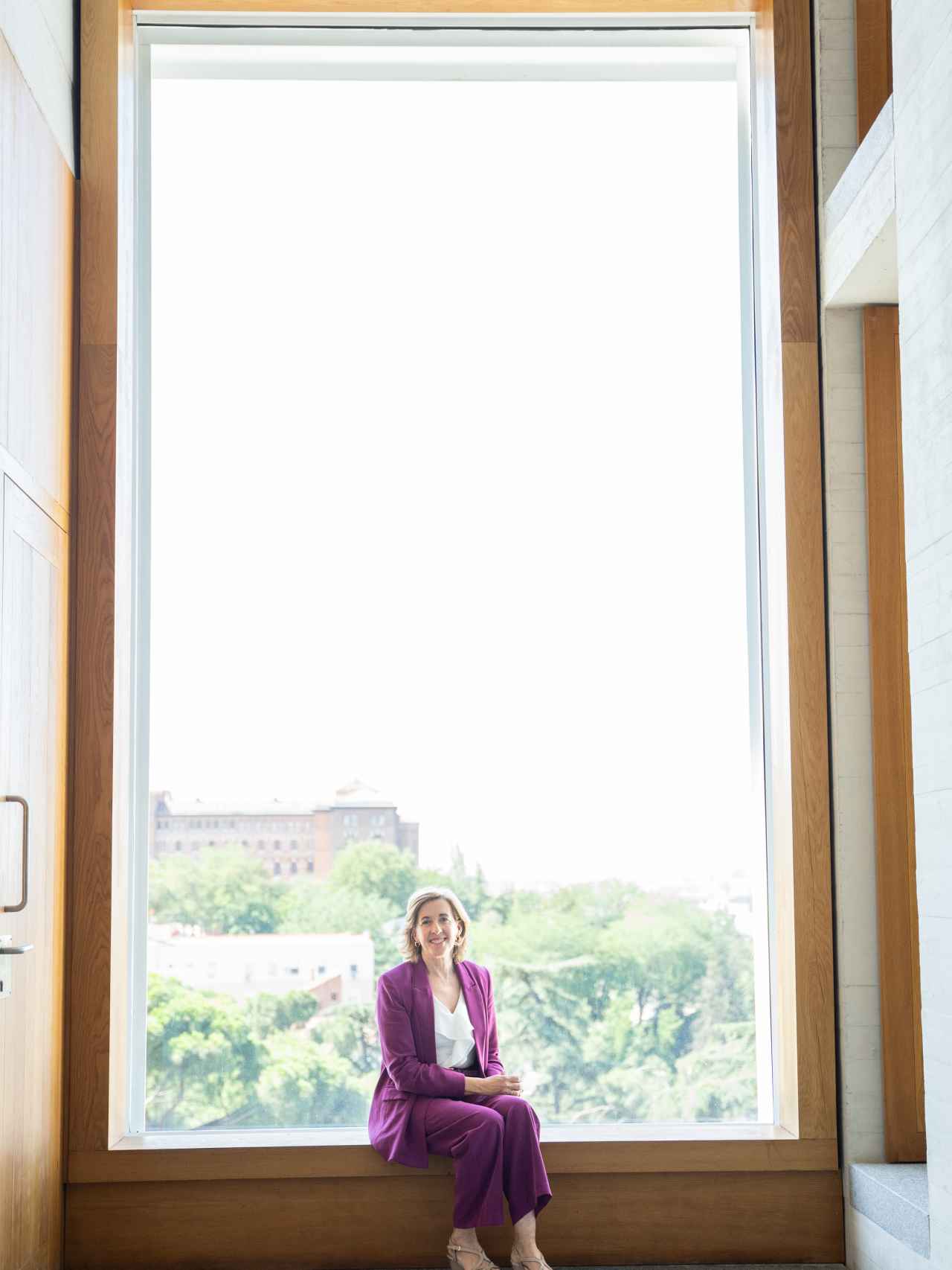 La presidenta delante de un gran ventanal del edificio.