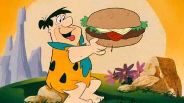 Pedro Picapiedra, comiendo una hamburguesa.