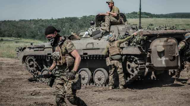 Soldados de infantería mecanizada de la Brigada 28 descienden del BMP-2 en el que entrenan