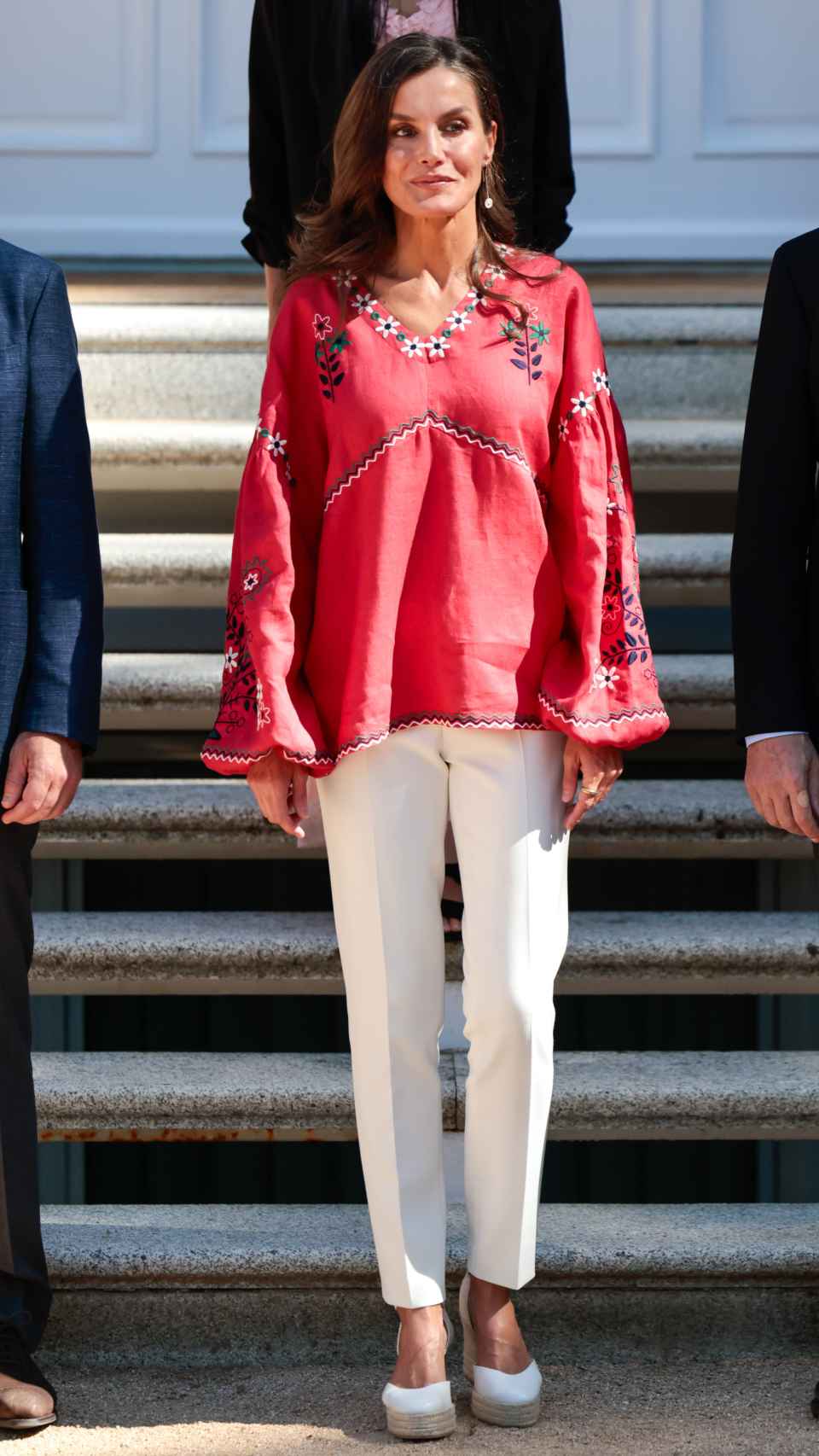 La Reina con blusa ucraniana, pantalones blanco y alpargatas.