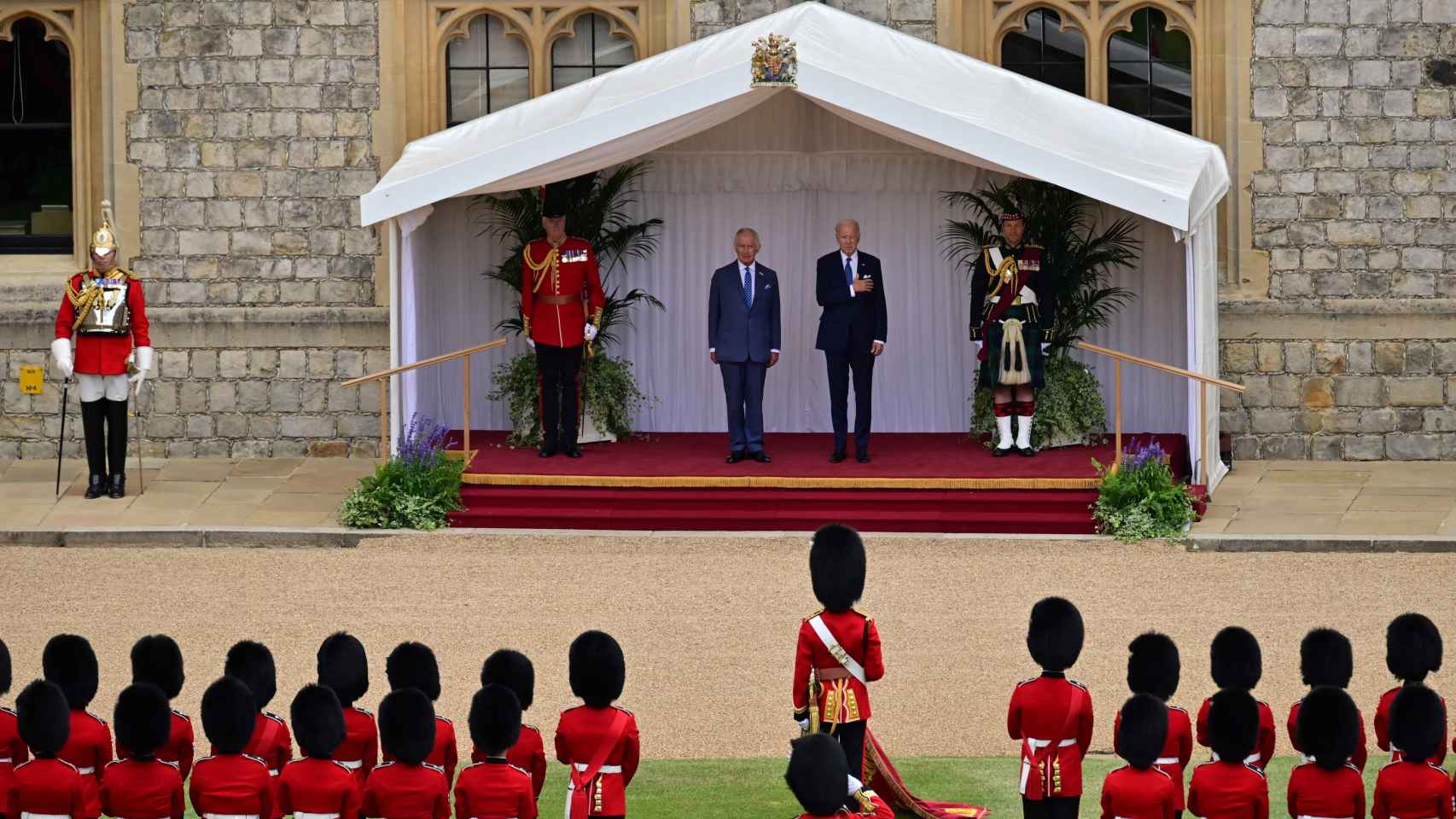 El presidente de los Estados Unidos, Joe Biden , y el rey Carlos de Gran Bretaña en el estrado, escuchan el himno nacional de los Estados Unidos interpretado por la Banda de la Guardia Galesa.