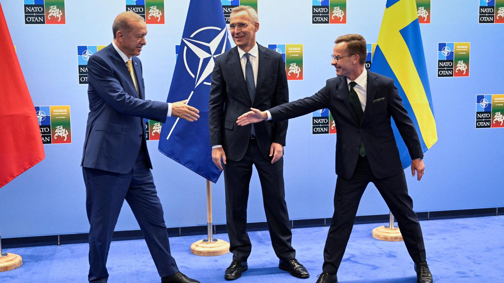 El presidente turco, Erdogan , y el primer ministro sueco, Kristersson, se dan la mano junto al secretario general de la OTAN, Stoltenberg, antes de su reunión en Vilna.
