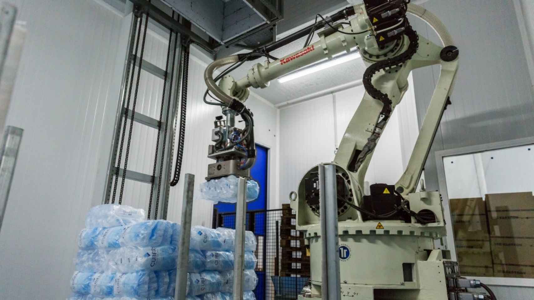 Un robot palentizador coloca los sacos de bolsas de hielo, ya envasadas, sobre los palés.