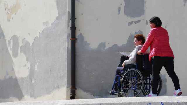 Imagen de archivo de una persona que acompaña a una paciente con movilidad reducida.