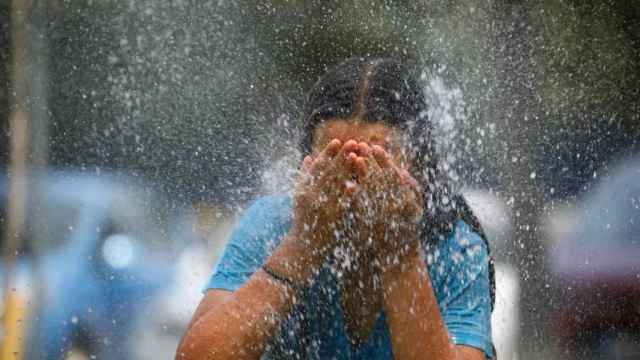 Una joven se refresca en una fuente en la ola de calor de esta semana.