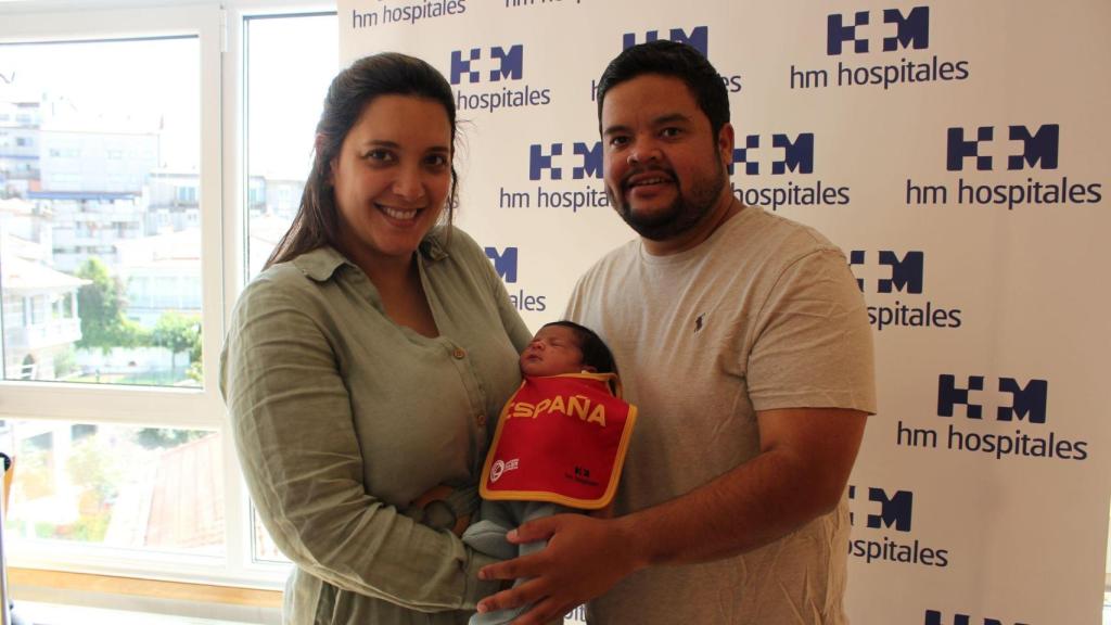 Una pareja con su bebé tras haber recibido el regalo conmemorativo de la FEB