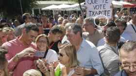 Pedro Sánchez junto a Juan Espadas en el sevillano barrio de Pino Montano, el 3 de septiembre de 2022. Al fondo, el creador anónimo del 'Que te vote Txapote' sujeta el cartel con el lema.