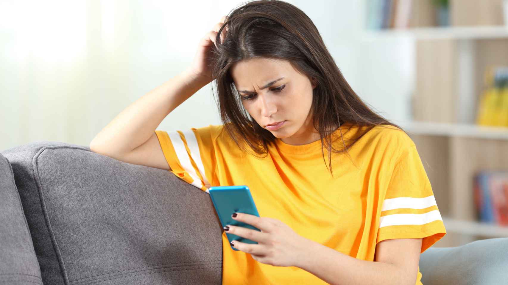 Adolescente preocupada leyendo su smartphone. Foto: iStock.