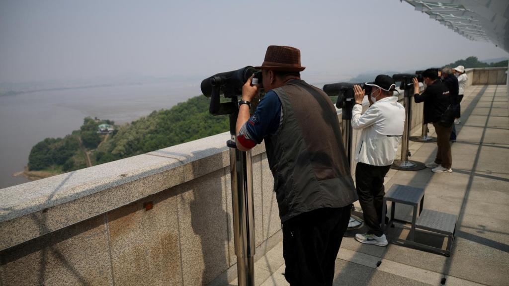Surcoreanos miran hacia el Norte con prismáticos en un puesto de observación cerca de la zona desmilitarizada que separa las dos Coreas.