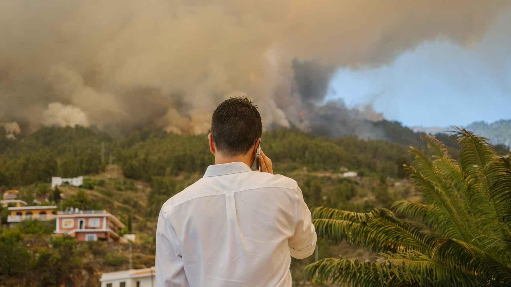 Gómez habla por teléfono en La Palma ante las llamas y el humo del incendio.