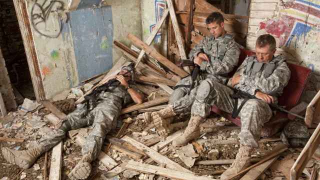 Varios militares duermen en un edificio abandonado.