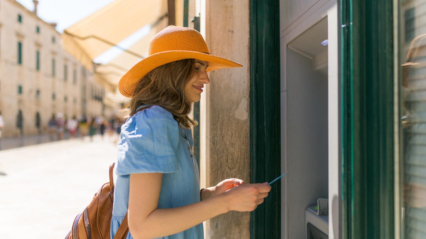 Una mujer, sacando dinero del cajero.