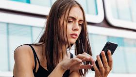 Mujer preocupada revisando mensajes en el teléfono móvil. Foto: iStock.