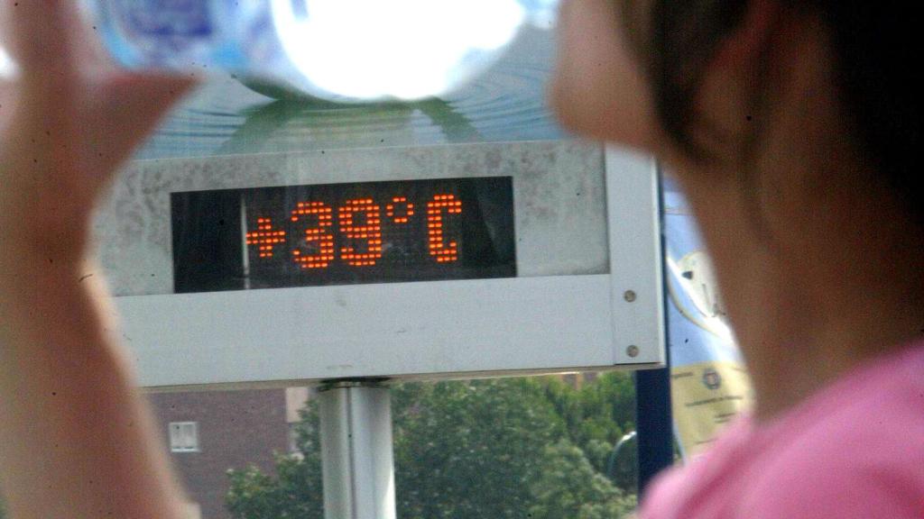Una mujer bebe agua en una calle de Valladolid con el termómetro marcando 39 grados.